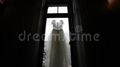 <strong>白色</strong>婚纱挂在阳台的<strong>光圈</strong>窗口和砖块场景中
